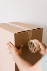Person sealing a moving box